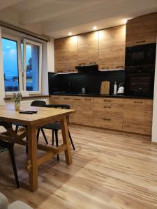 une cuisine avec une table en bois et une salle à manger dans l'établissement GOLDEN ROOMS blisko Energylandii, à Zator