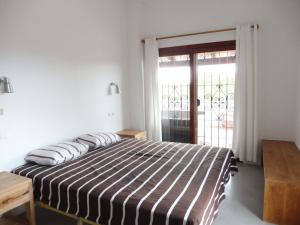 a bedroom with a bed and a sliding glass door at Belvilla by OYO Casa Loma in Cala Tarida