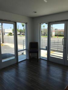 a room with sliding glass doors and a chair at Castaway Motel in Orange