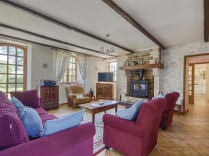 sala de estar con muebles de color púrpura y chimenea en Enticing Holiday Home in Berigny with Swimming Pool en Bérigny