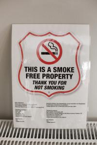 un cartello su uno scaffale con un cartello con sopra un segno di fumo di SWEET HOME vipgreece ad Atene