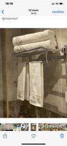 eine Seite eines Badezimmers mit Handtüchern auf einem Kleiderständer in der Unterkunft Sôsuite in Saly Portudal