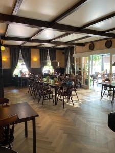 un restaurante con mesas y sillas en una habitación en Hotel Eetcafé 't Dûke Lûk en Veenwoudsterwal