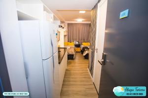 um corredor que leva a um quarto com um frigorífico em All You Need - 608 em Curitiba