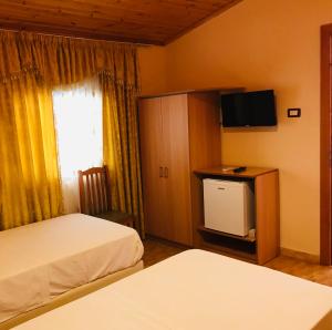 pokój hotelowy z 2 łóżkami i telewizorem z płaskim ekranem w obiekcie Gold Guest House & Bar w mieście Përmet