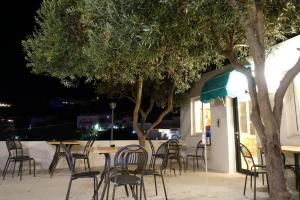 un groupe de tables et de chaises devant un bâtiment dans l'établissement Il Capriccio Guesthouse, à Ponza