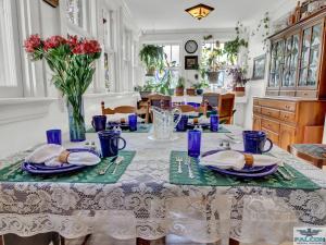 une salle à manger dotée d'une table avec des plats bleus et des fleurs dans l'établissement Robins Nest Bed & Breakfast, à Cody