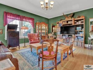 a living room with green walls and a table and chairs at Robins Nest Bed & Breakfast in Cody