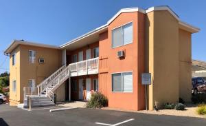 un immeuble avec des escaliers dans un parking dans l'établissement Sunbeam Motel, à San Luis Obispo
