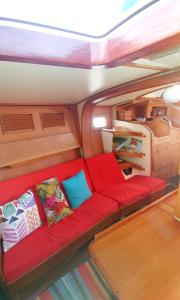 a red couch in the back of a boat at Bateau Kyma in Sainte-Anne