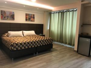 1 dormitorio con 1 cama grande y cortinas verdes en Hotel Lexus, en Lima