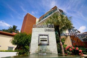 a hotel with a fountain in front of a building at Ramaburin Resort Patong - SHA Extra Plus in Patong Beach