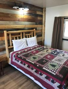 a bedroom with a bed with a quilt on it at Fox n Fireweed Cabins in Tok