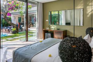 a bedroom with a bed with a large mirror at Kembali Villas in Seminyak +37 photos