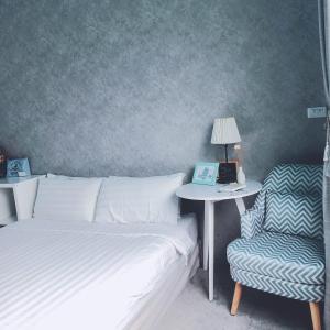 a bedroom with a bed and a table and a chair at EATzzZ Hostel in Kaohsiung