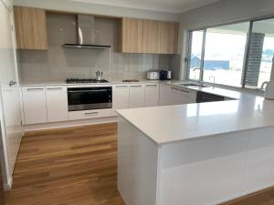 a kitchen with white cabinets and a white counter top at Rosehill Vines in Millfield