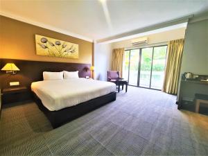 a hotel room with a bed and a large window at Merdeka Hotel Kluang in Kluang