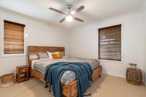 a bedroom with a bed and a ceiling fan at Oceanic Blue - East Ballina in East Ballina