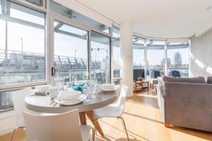 a white dining room with a table and chairs at Historic Waterside With Spectacular Johnson Bridge Views in Victoria