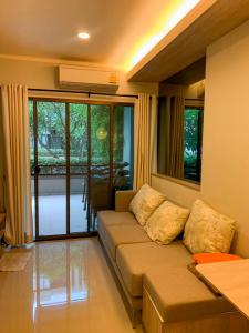 a living room with a couch and a window at lumpini park beach in Cha Am