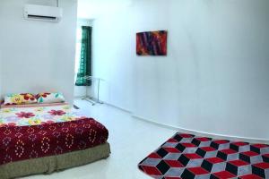 1 dormitorio con cama y alfombra en Near Draw Bridge and KT City - Ivana Homestay Unit E, en Kuala Terengganu