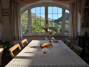 a dining room table with a lamp and a large window at Villa Maria in Dorgali