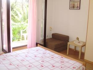 a bedroom with a bed and a couch and a window at Villa Welcome in Vrboska