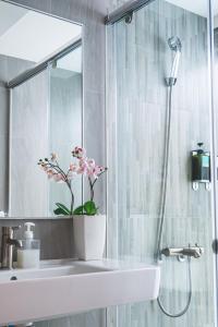 台南Viva漁樂活台南安平民宿的浴室设有水槽和植物淋浴