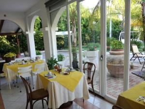 a dining room with tables with yellow tablecloths at B&B Villa Di Bartolomeo in Capaccio-Paestum