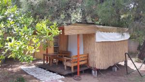a small wooden house with a table and a bench at Secret Garden Hotel & Bungalows in Cıralı