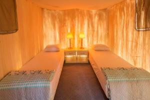 two beds in a small room with two lamps at Secret Garden Hotel & Bungalows in Cıralı
