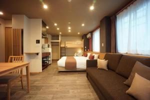 WIRES HOTEL James zaka في طوكيو: غرفه فندقيه بسرير واريكه