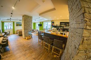 a bar in a restaurant with a stone wall at Hotel ALPINA in Saalbach-Hinterglemm