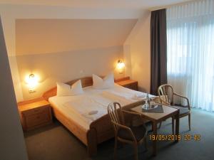 a bedroom with a bed and a table and chairs at Hotel Merle in Bruttig-Fankel