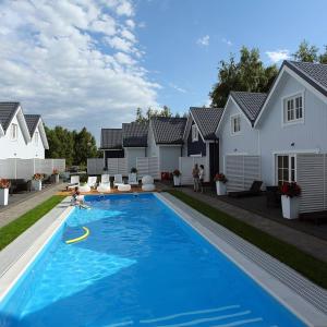 a swimming pool in a yard with houses at RODZINKA B&M in Niechorze
