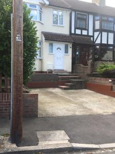 a house with a white door and a driveway at Single Room G1 (Sandycroft Guest House) in London