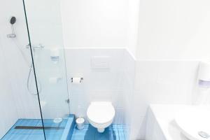 a bathroom with a toilet and a glass shower at Maverick City Lodge in Budapest