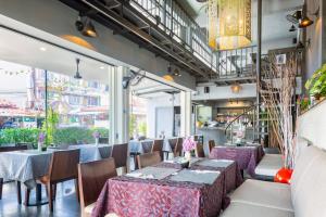 a restaurant with tables and chairs and windows at CHA AM MY HOUSE Resort in Cha Am