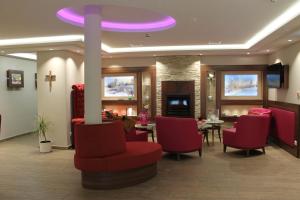 a waiting room with a table and chairs and a purple ceiling at Hotel Number One in Waidhaus