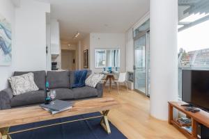 a living room with a couch and a table at Historic Waterside With Spectacular Johnson Bridge Views in Victoria