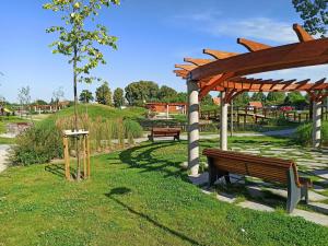 een park met banken en een houten paviljoen bij Apartament MIŁOSZA in Ełk