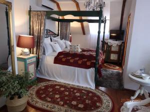 a bedroom with a canopy bed and a mirror at Casa Cositorarului Boutique Pension in Sighişoara