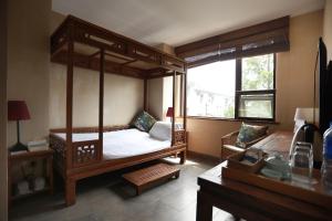 sypialnia z łóżkiem z baldachimem i oknem w obiekcie TOP ZERO HOTEL w mieście Wudangshan