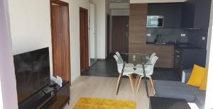 a living room with a table and chairs and a kitchen at GalériusPrémium6 in Siófok