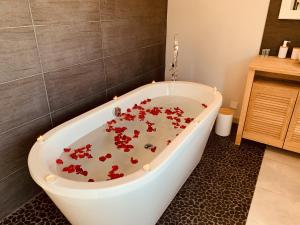 baño con bañera llena de flores rojas en Villa Holidays - Piscine chauffée et privée - clim - wifi - parking privée - Netflix, en Grabels