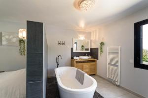 Baño blanco con bañera y lavamanos en Villa Holidays - Piscine chauffée et privée - clim - wifi - parking privée - Netflix, en Grabels