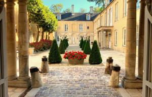 um pátio com árvores de Natal e flores num edifício em Le Tardif, Noble Guesthouse em Bayeux