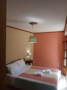 a bedroom with a bed with two towels on it at Small Town Apartment in Konitsa