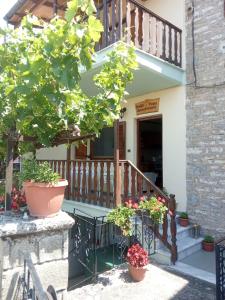 a porch of a house with a table and flowers at Small Town Apartment in Konitsa