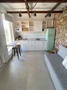 a kitchen with white cabinets and a table and a refrigerator at Oliva in Faliraki